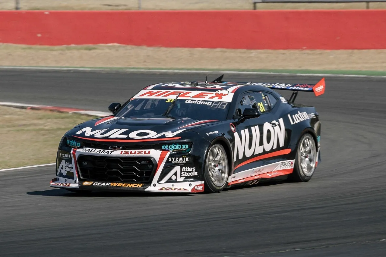 The black number 31 Nulon Racing Camaro cornering on a test day, with a red wall behind