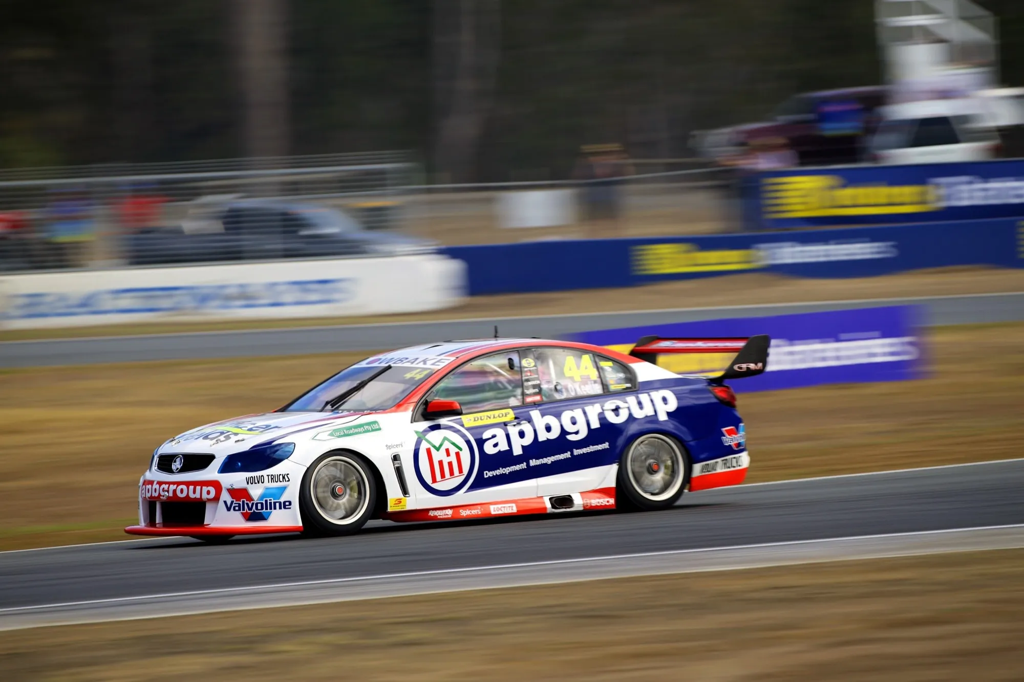 Side view of the #44 apbgroup Commodore Supercar at speed on a circuit, background blurred