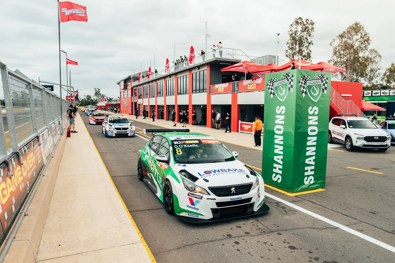 The #8 Schaeffler Peugeot TCR car in pit lane with other TCR cars queued behind and a Shannons banner