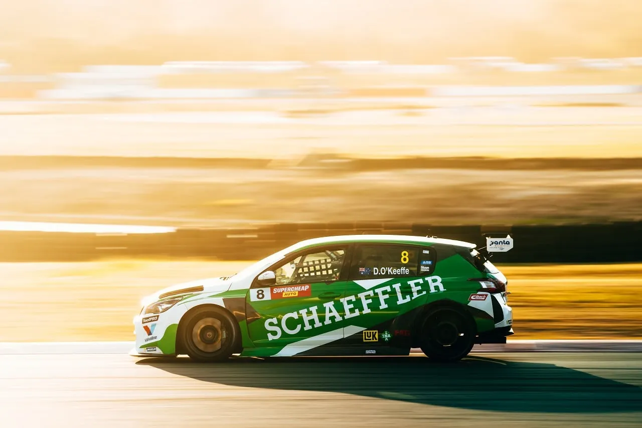 The #8 Schaeffler Peugeot 308 TCR car in side profile at sunset, panned for motion blur