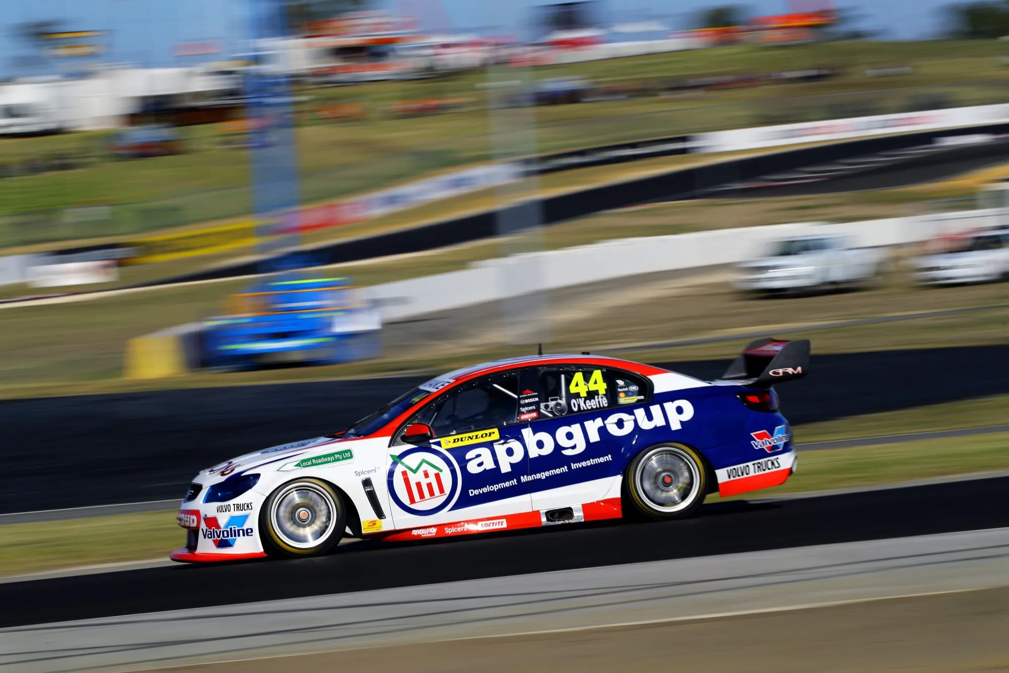 The #44 apbgroup Commodore Supercar at speed with motion blur on an open circuit