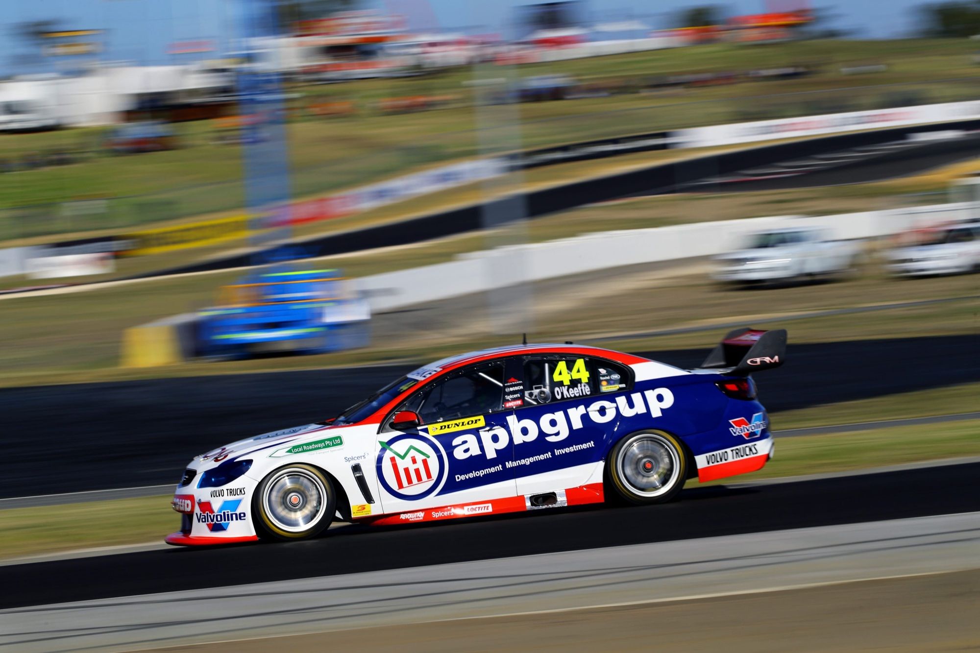 The #44 apbgroup Commodore Supercar at speed with motion blur on an open circuit