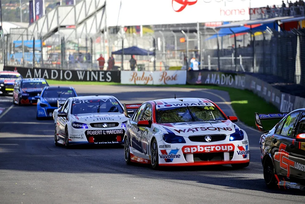 The #44 apbgroup Watsons Commodore Supercar racing in a group of Supercars on a street circuit