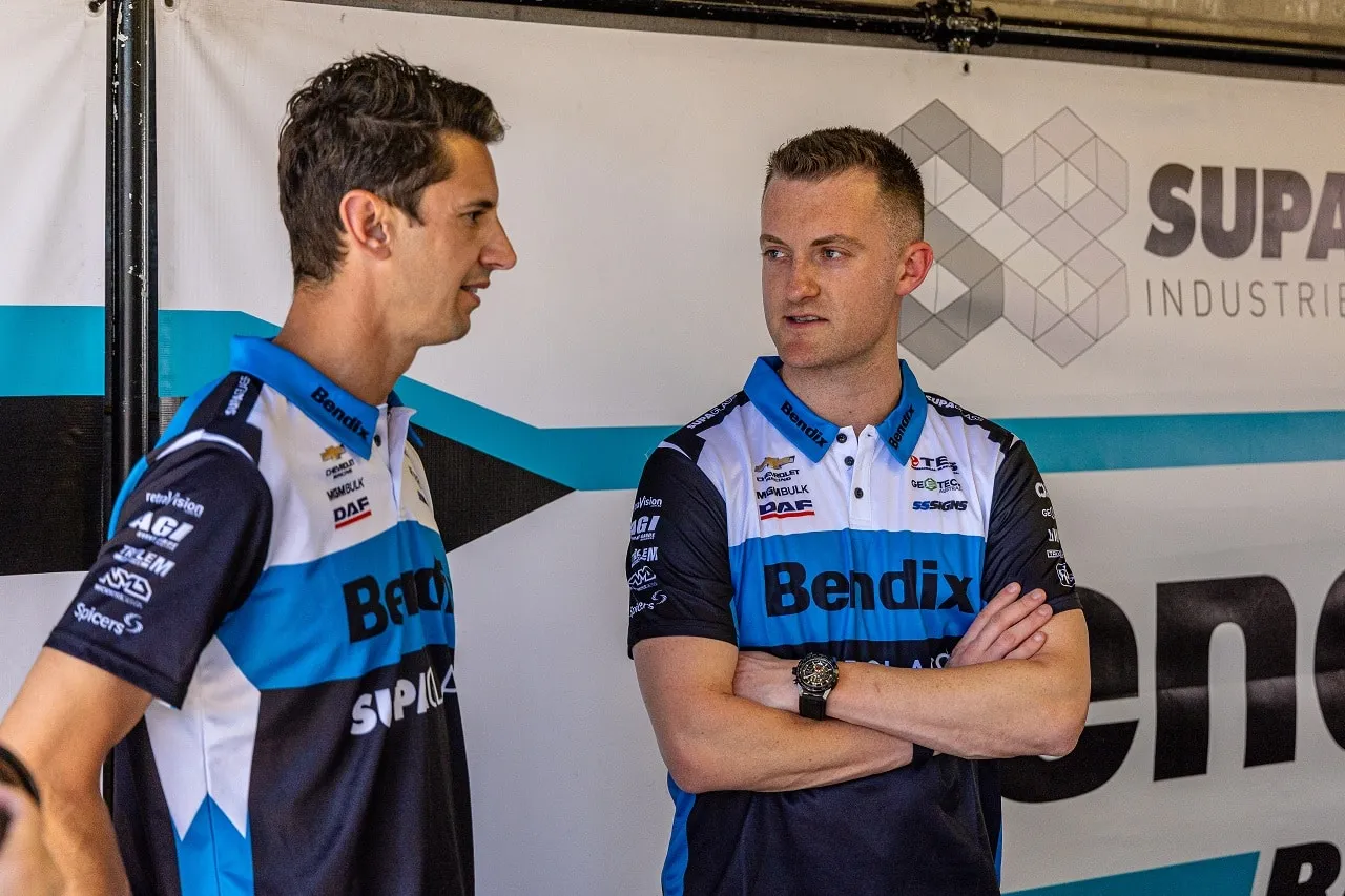 Nick Percat and Dylan O’Keeffe in Bendix Matt Stone Racing shirts chatting in front of a team banner