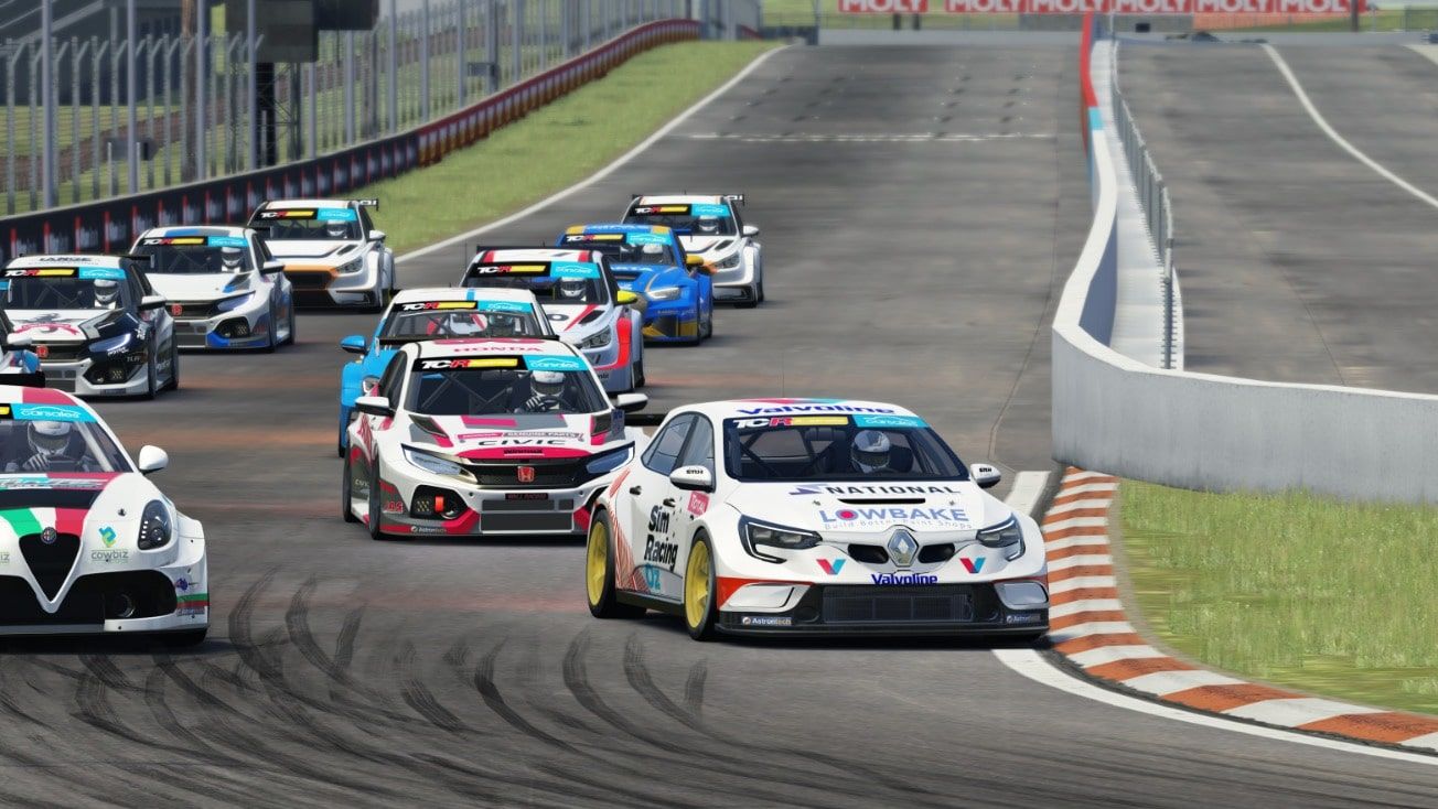Sim racing screenshot of a pack of TCR cars at speed, led by the white Renault, on a circuit with orange and white kerbs