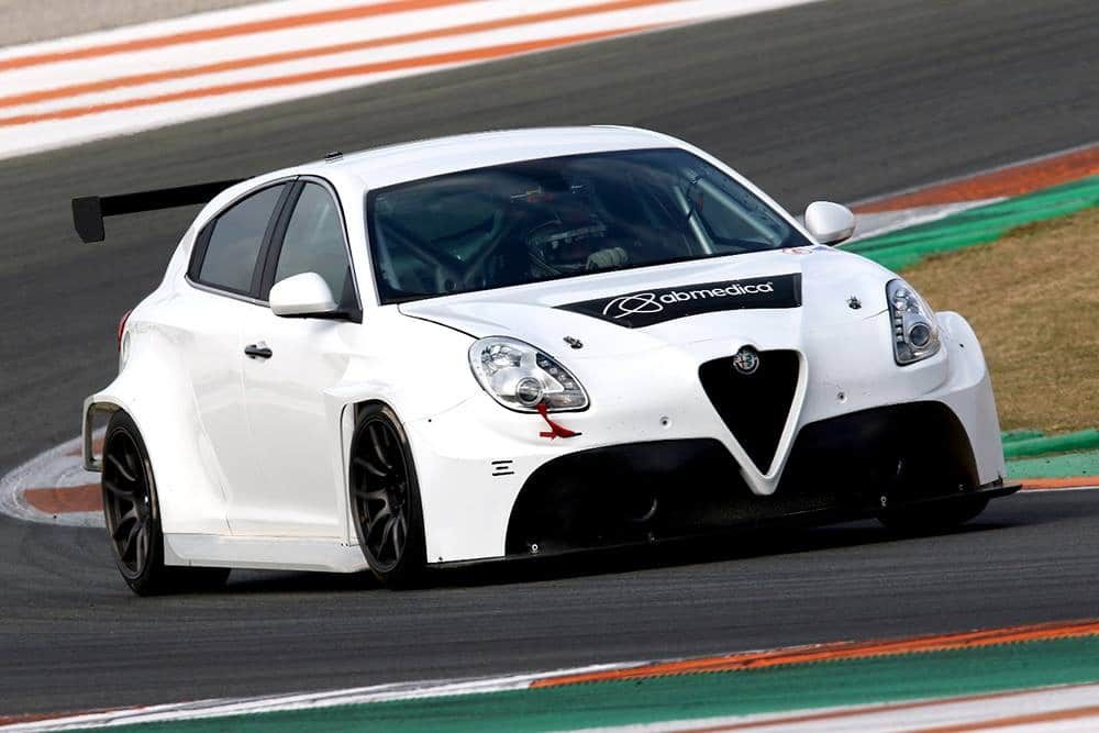 A white Alfa Romeo Giulietta TCR car cornering on a race track during testing