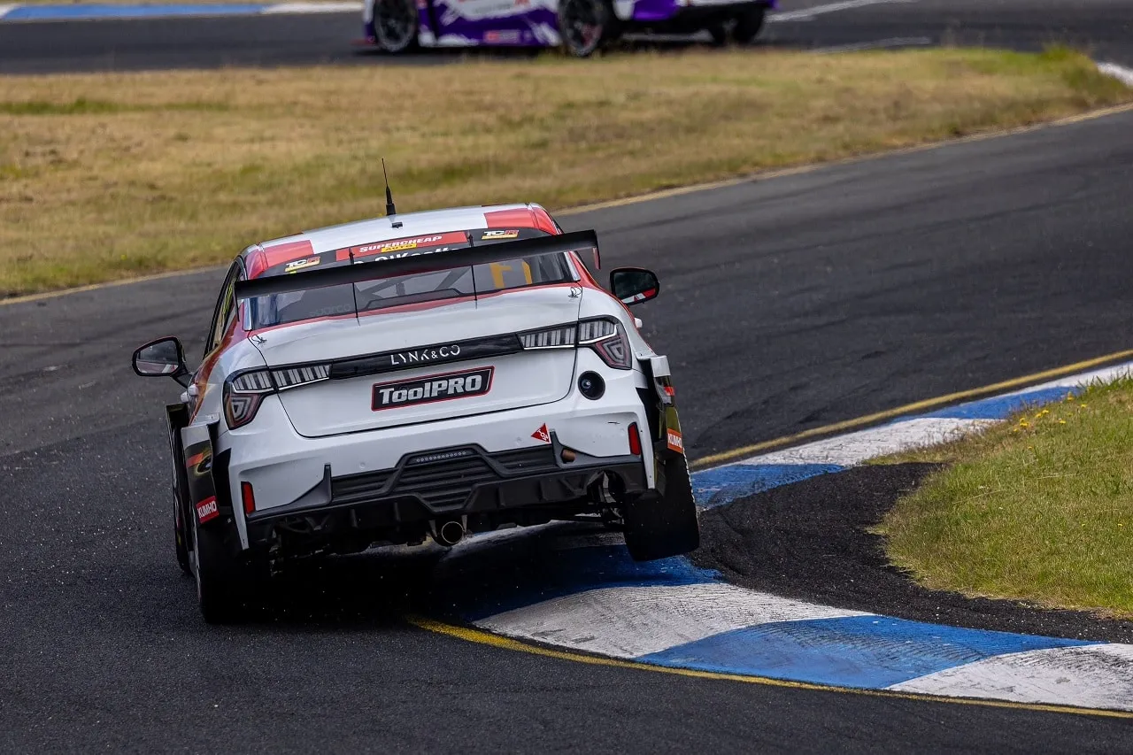 Rear view of the Lynk & Co TCR car with a ToolPRO number plate, running over the kerb through a corner at Sandown