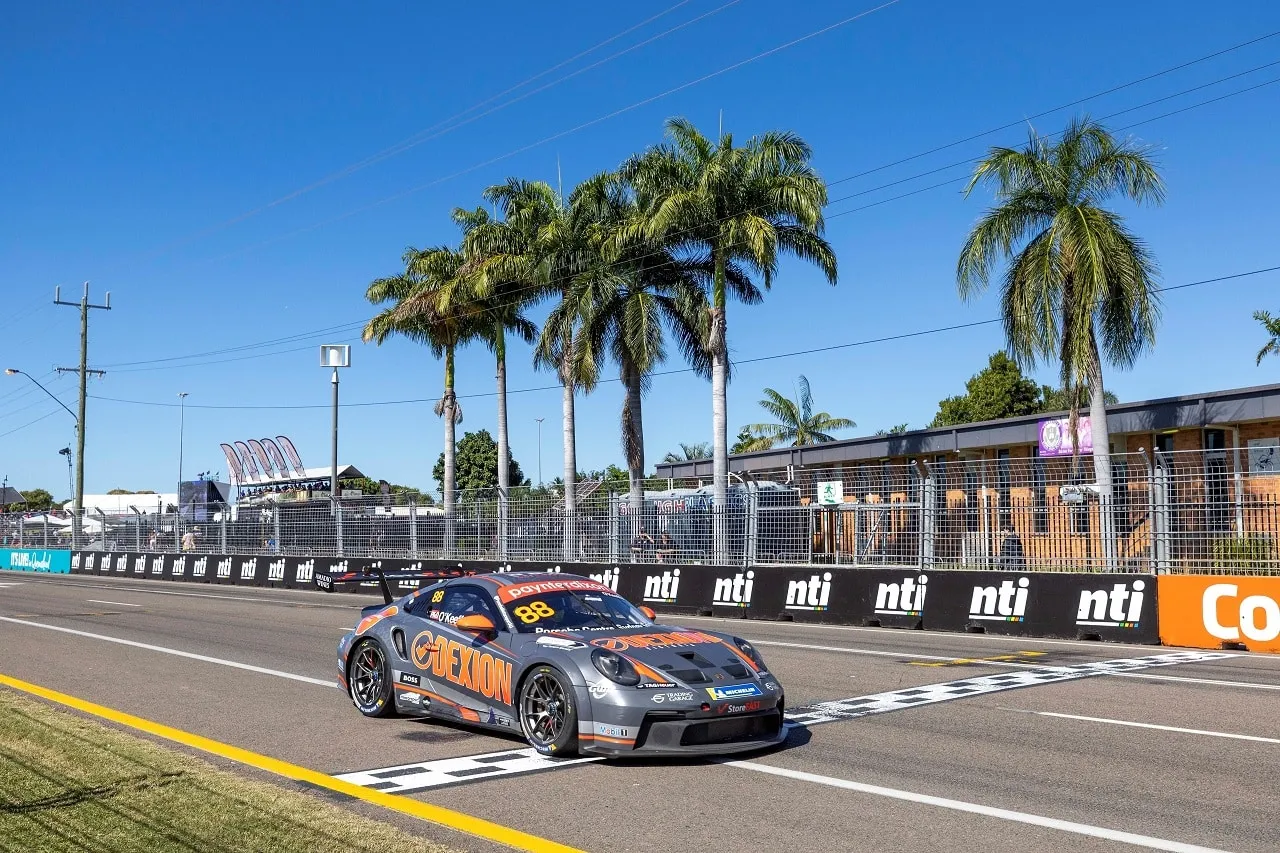 The #88 Dexion Porsche GT3 Cup car crosses the start-finish line on a street circuit lined with palm trees