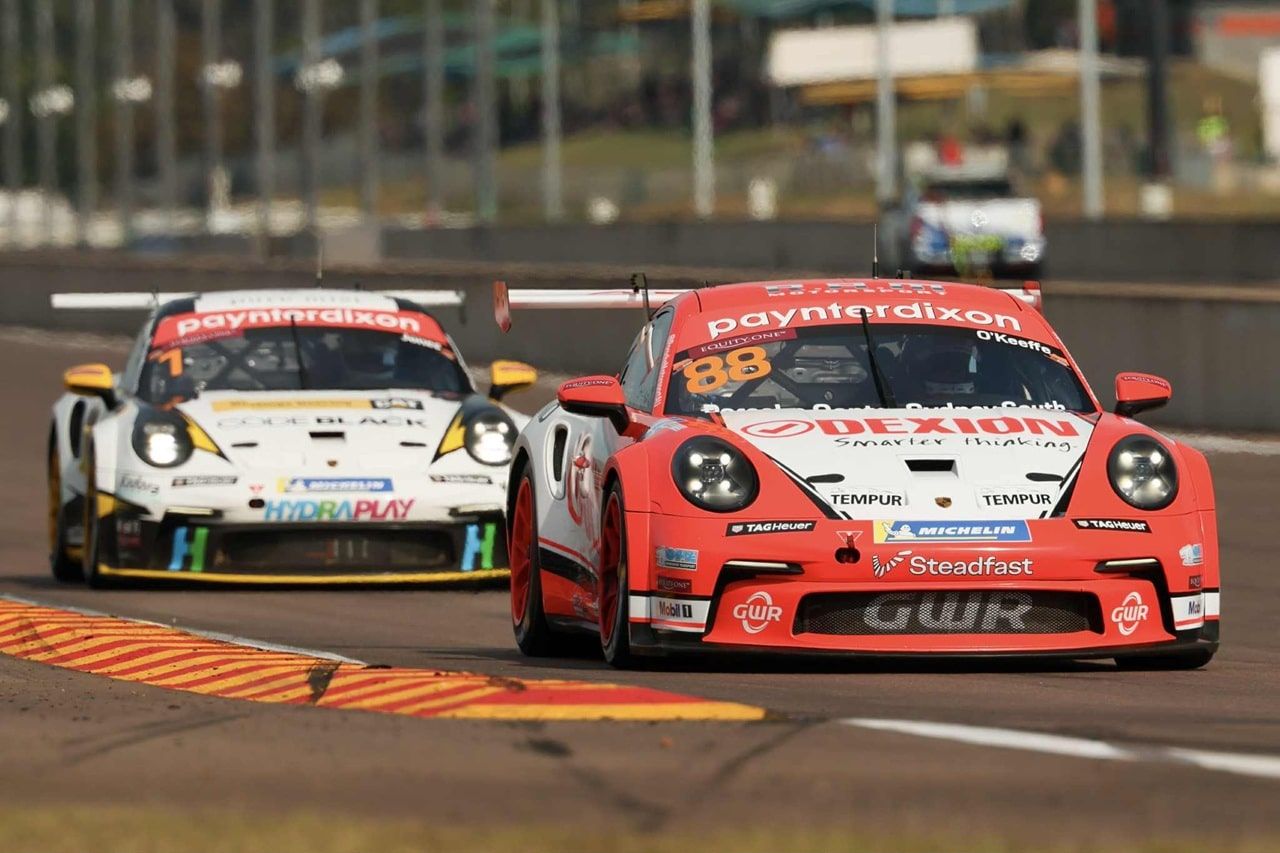 Dexion Porsche #88 racing closely alongside a white Porsche