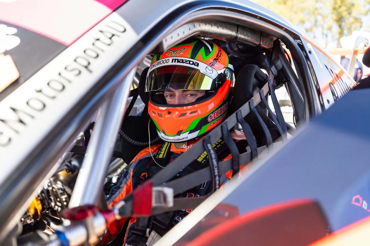 Dylan O’Keeffe strapped into the Porsche cockpit in his helmet