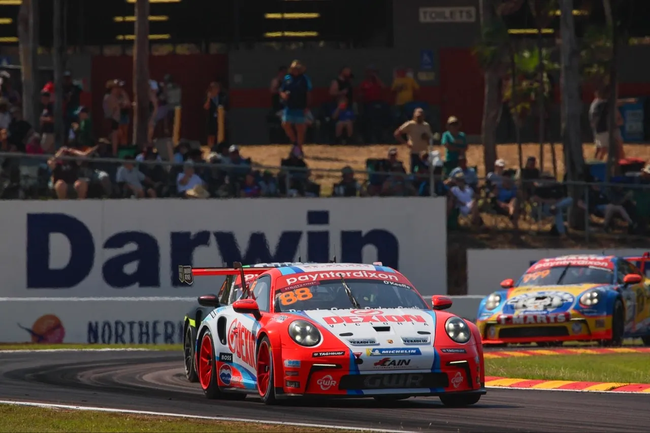Number 88 Dexion Porsche Carrera Cup car on track in front of a Darwin sign and grandstand spectators
