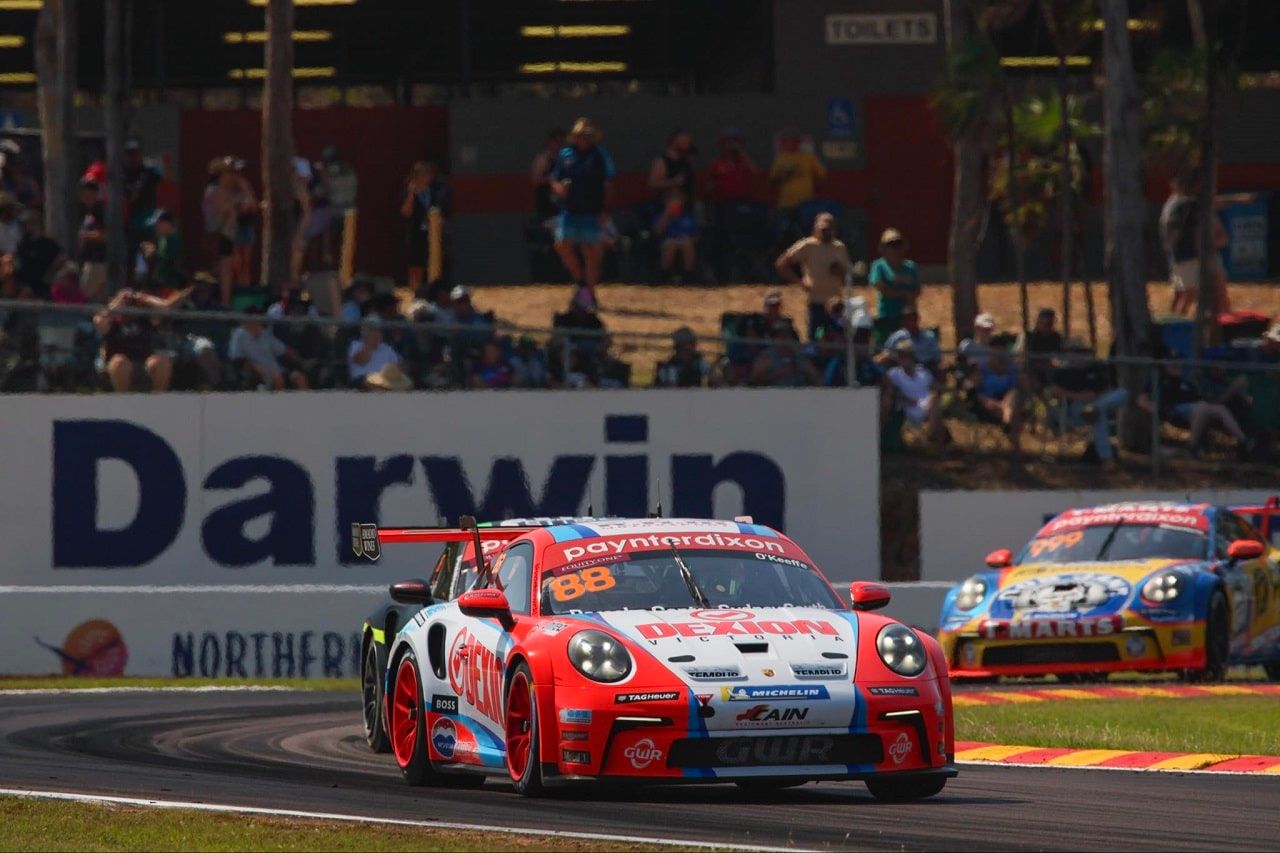 Number 88 Dexion Porsche Carrera Cup car on track in front of a Darwin sign and grandstand spectators