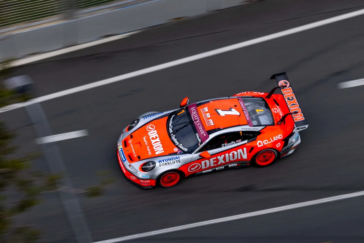 Overhead view of the #1 Dexion Porsche at speed between the painted lines of the Gold Coast street circuit