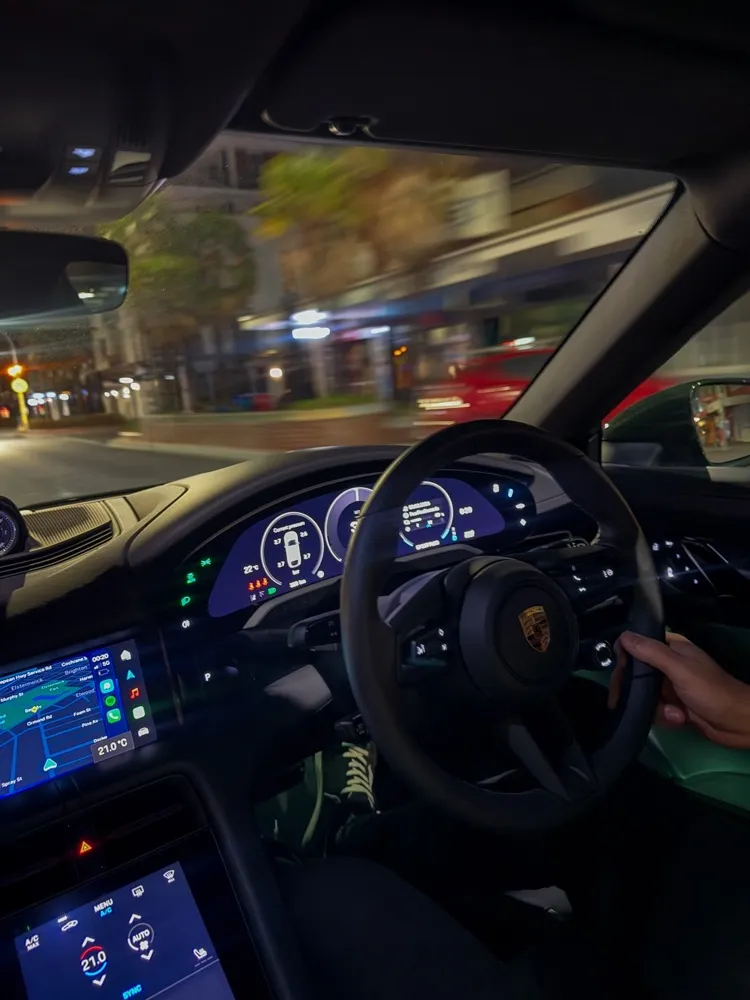 Cockpit view of a Porsche’s steering wheel and dashboard at night