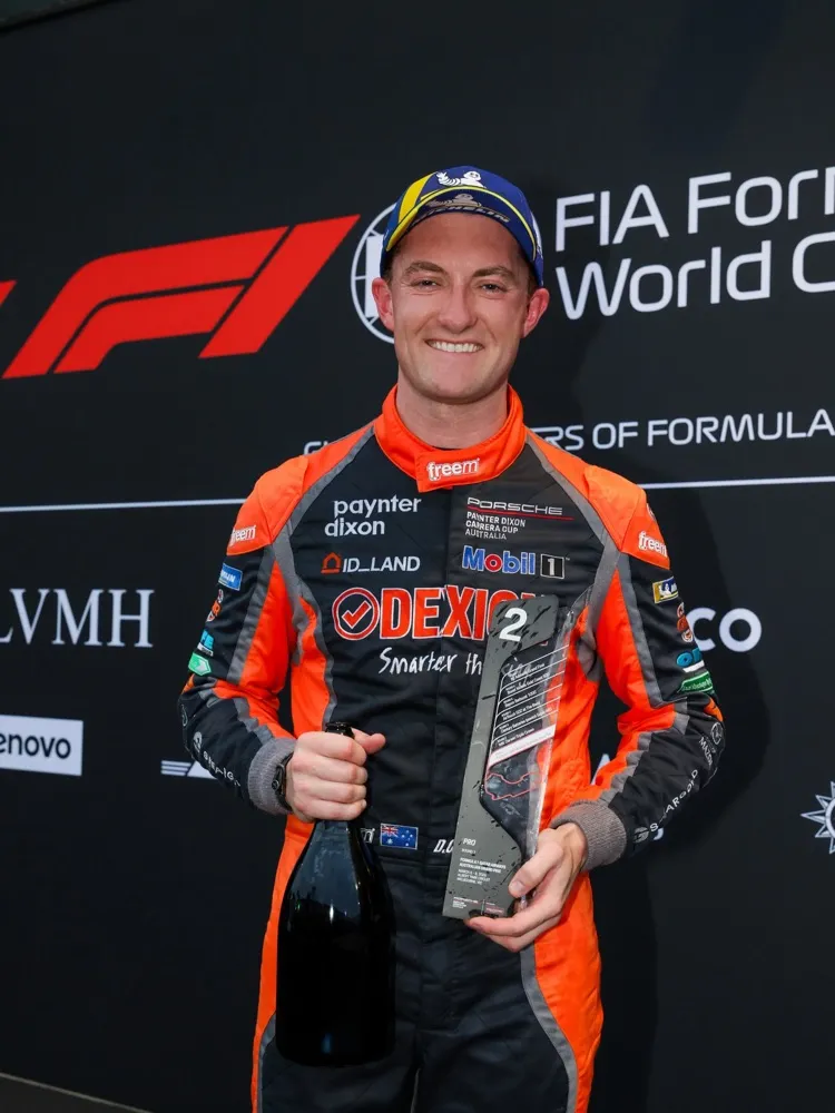 Dylan O’Keeffe in his Dexion race suit holding a second-place trophy at the Australian Grand Prix