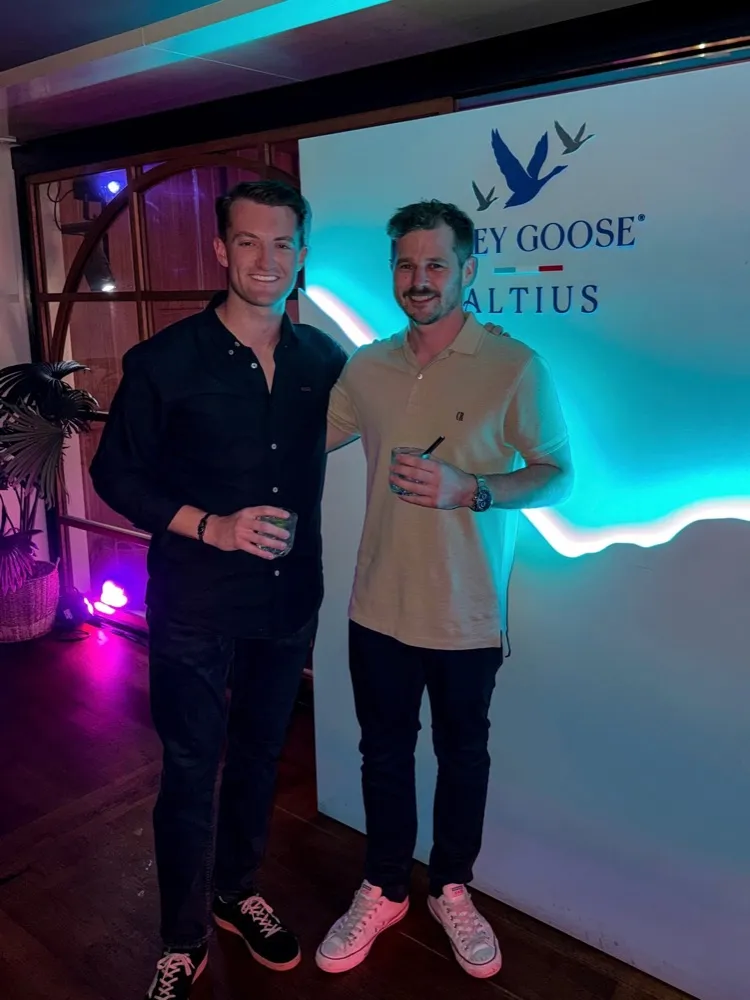 Two men at an event in front of a lit Grey Goose Altius backdrop